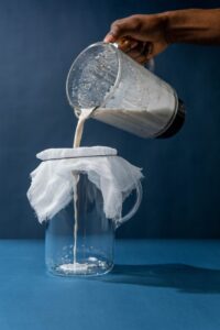 straining milk from blended almonds